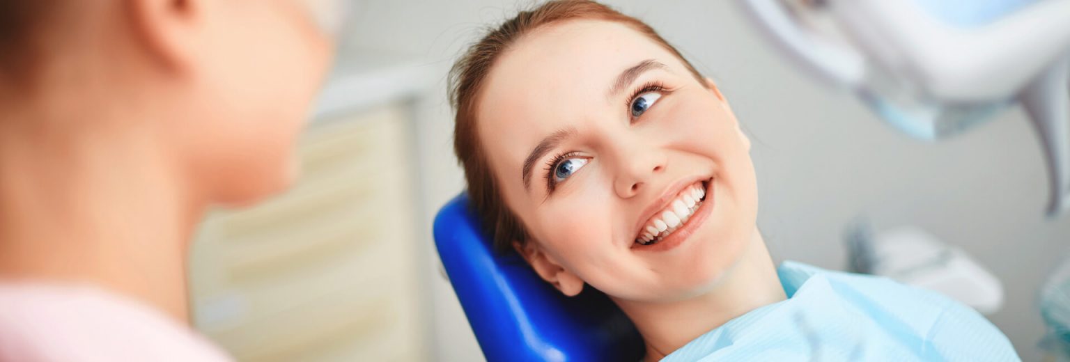 Happy lady sitting on a dental chair